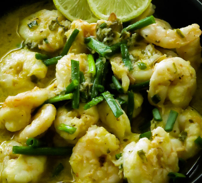 garlic butter shrimp in a bowl served with lime wedges
