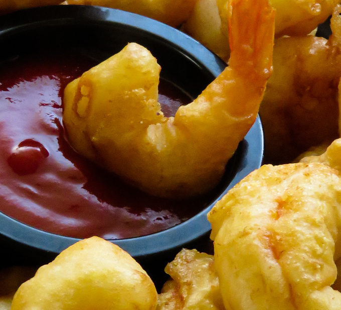 batter fried shrimp dipped in sauce.