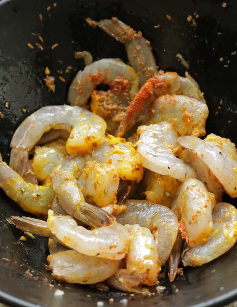 marinating the prawns with spices, ginger and garlic to make the prawn masala.