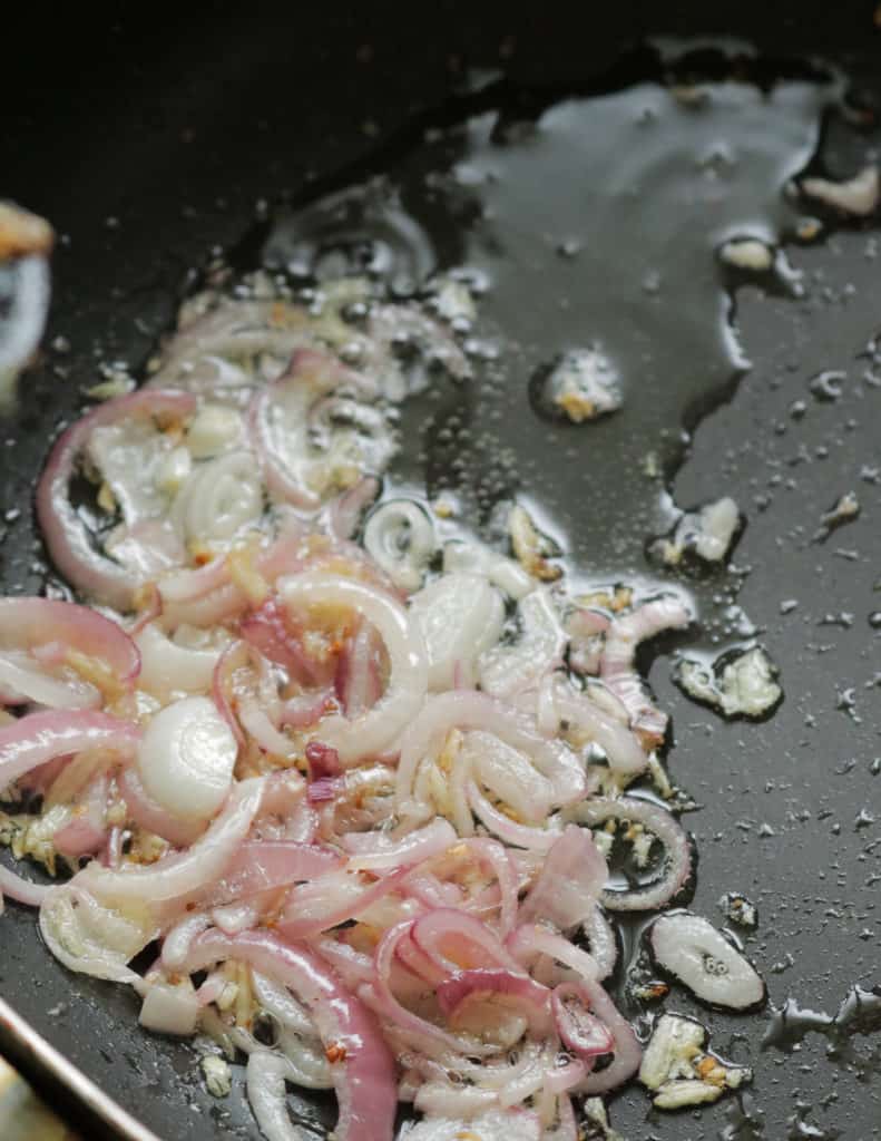 frying the onions, ginger, garlic to make the Indian prawn masala curry.