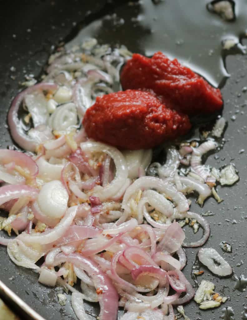 adding tomato paste with the frying onions,ginger,garlic to make the prawn masala curry recipe.