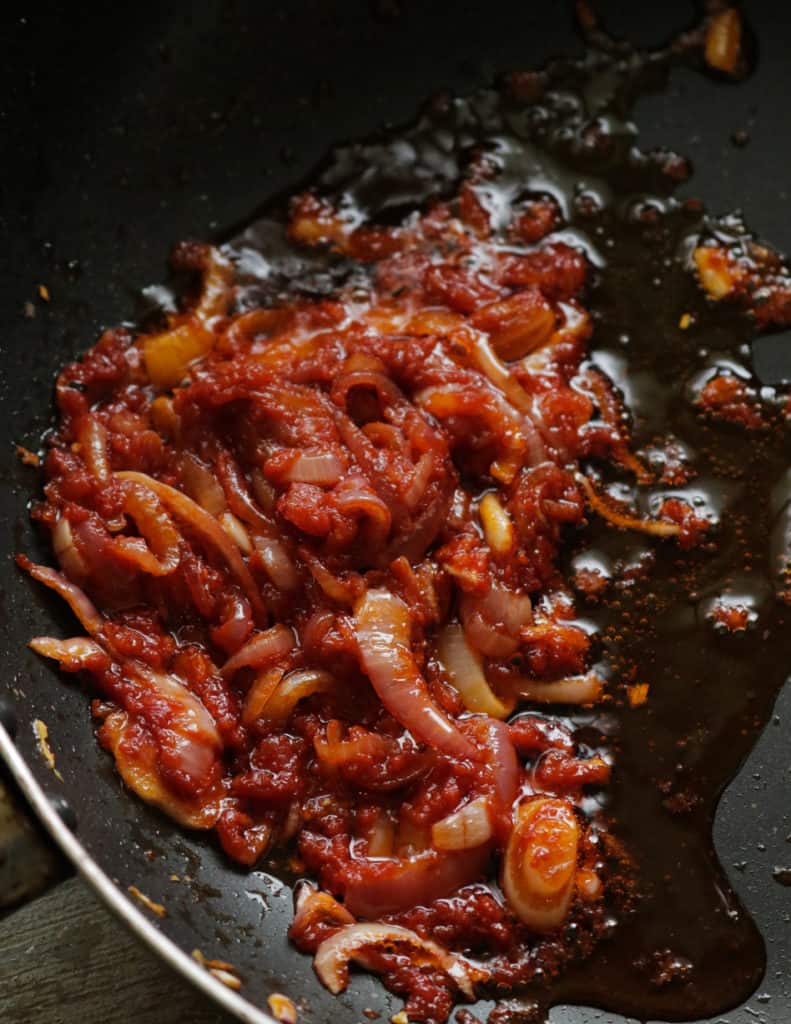 cooking the onions,spice powders, garlic and tomato paste until oil separates to cook the prawn masala.