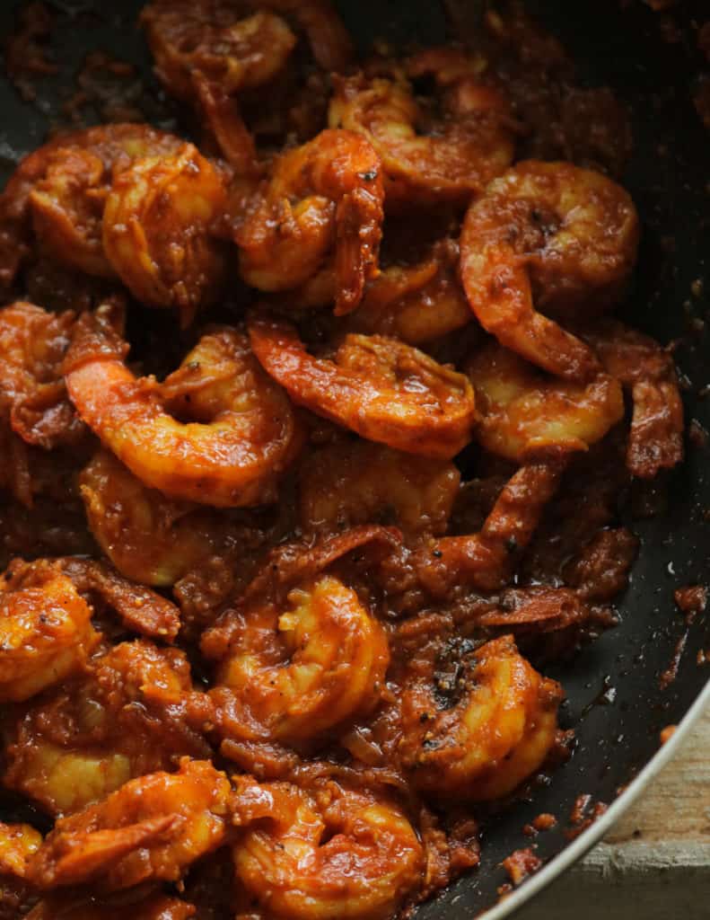 Cooking the prawns over low heat with the masala paste.