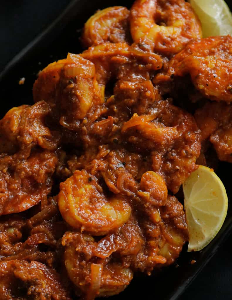 Indian style prawn masala curry served in a black platter.