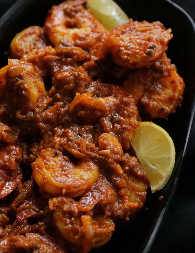 thick prawn masala curry with lime slices.