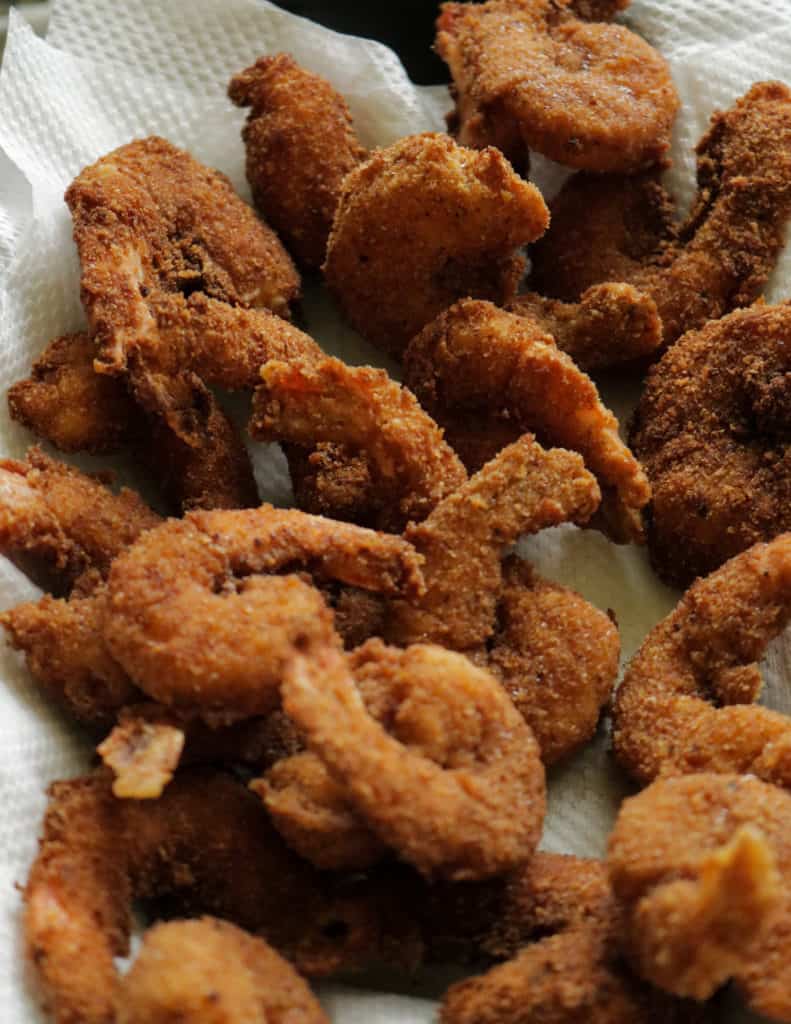 crispy fried breaded shrimp kept on paper kitchen towels to soak in any excess oil.