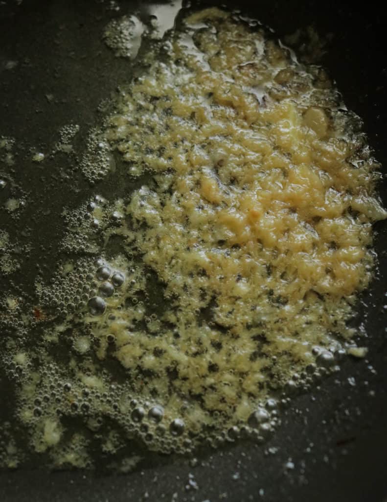 cooking the minced ginger to make the prawn korma.