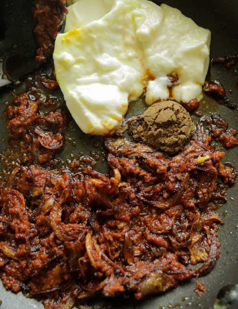 adding the yogurt and curry powders to the korma paste to make the prawn korma.