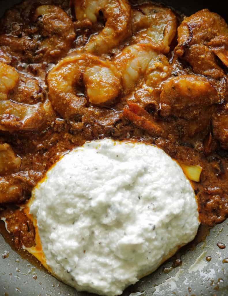 adding the ground coconut and cashew paste to make the prawn korma.