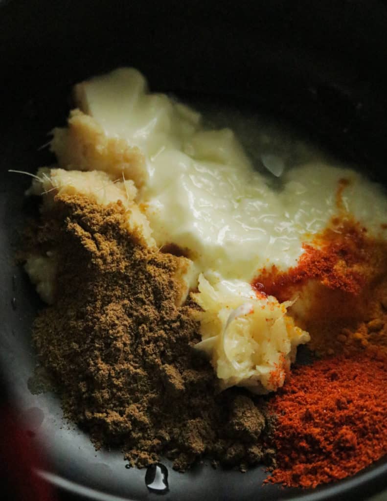 mixing the spices to make the tandoori shrimp in a bowl.