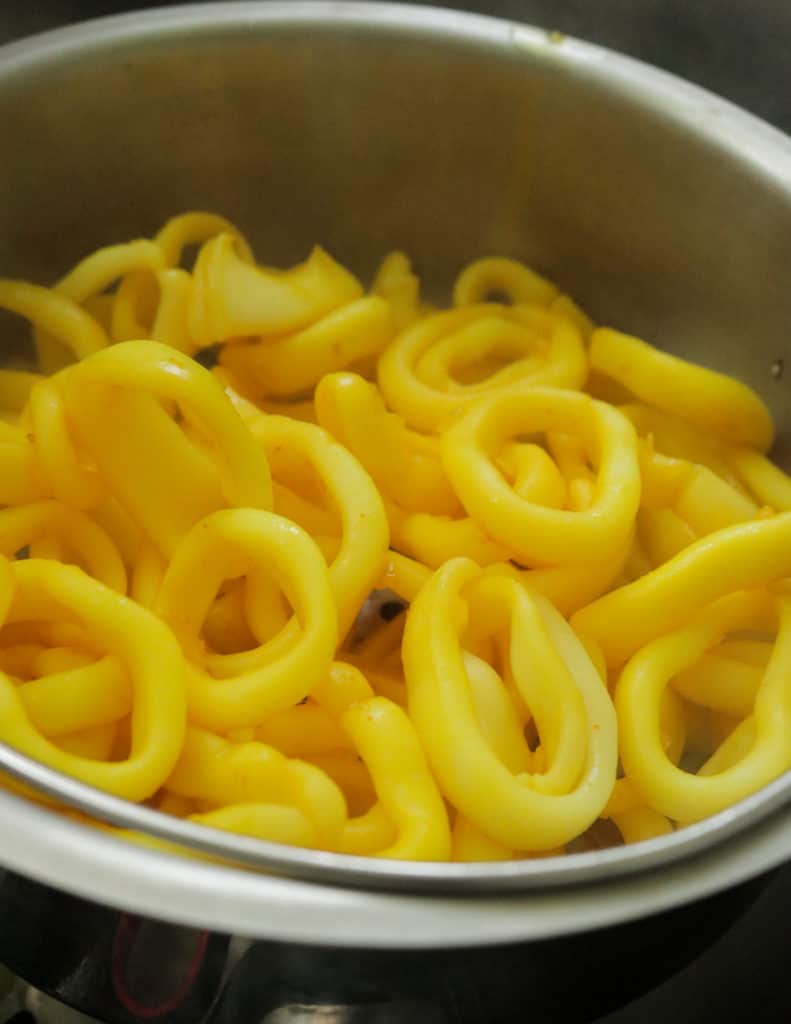 boiling the squid with turmeric powder to cook calamari or squid curry.