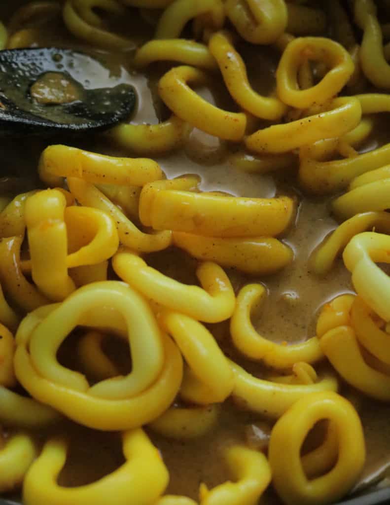 adding the boiled squid to the curry gravy to make the squid curry.