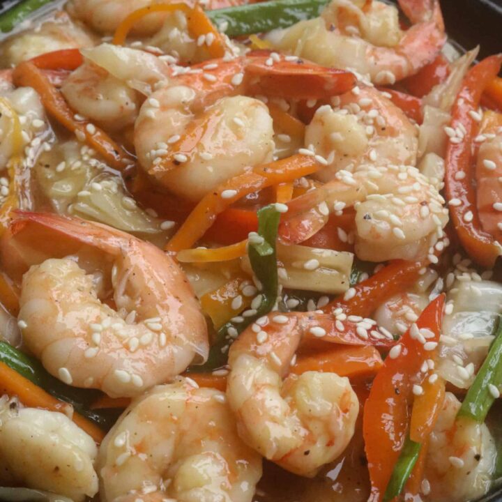 shrimp stir fry with vegetables and garnished with sesame seeds.