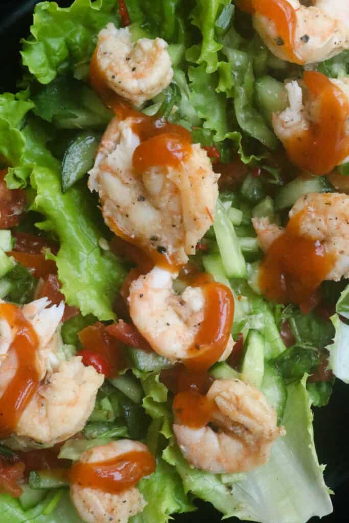 shrimp lettuce wraps. cooked shrimp with cucumber, tomatoes and drizzled with sauce.